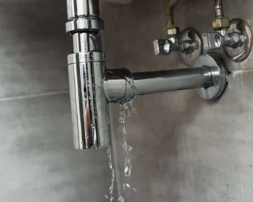 leaky-chrome-pipe-with-water-damage-on-wall-2026-03-12-23-52-28-utc